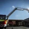 An aerial ladder platform extended from a fire engine in the sun
