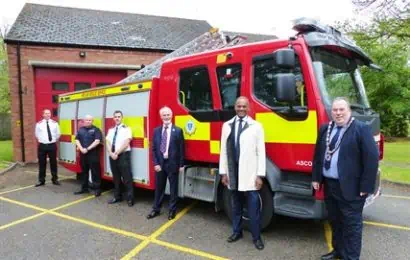A group of people stand next to a Fire Engine outside Ascot Fire Station