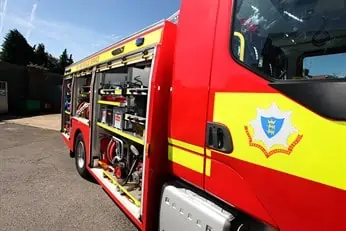 close up banner image of side of fire engine with compartments open and focus on the rbfrs crest