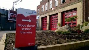 The front of Caversham road fire station with a sign outside saying blood donor session this way