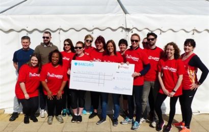 Staff holding a money raised for charity