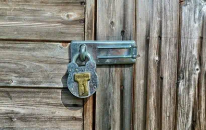 photo of wooden garden shed door with silver lock and padlock