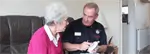 Man demonstrates how to test a smoke alarm to a woman