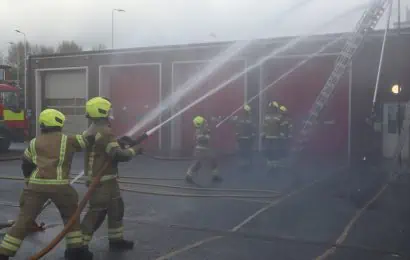 Firefighters training with a hose reel