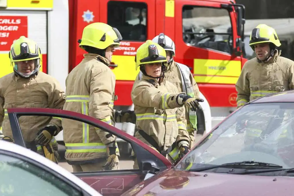 Firefighter pointing at a car after a crash