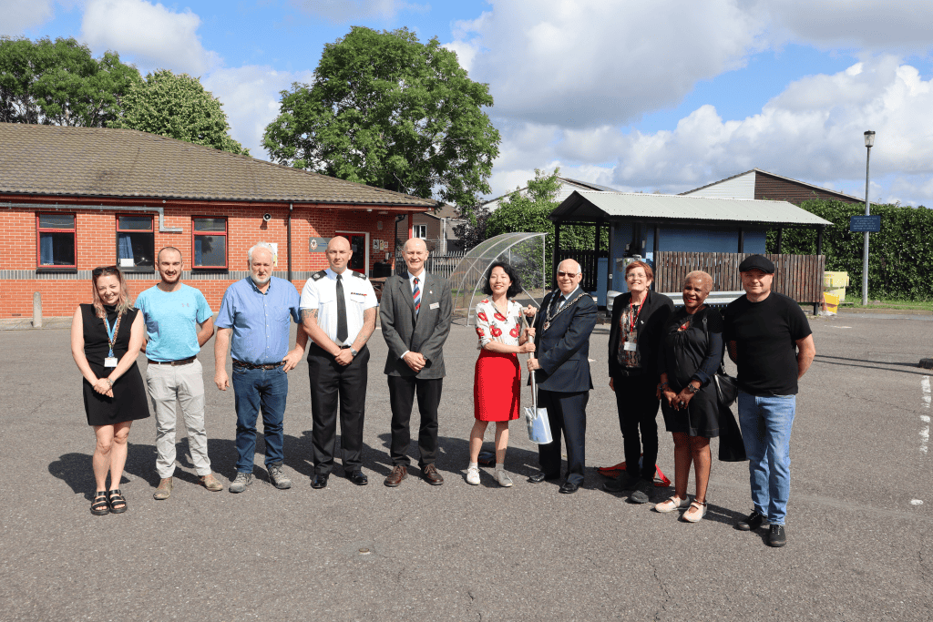 Ten people standing in a line at a groundbreaking ceremony