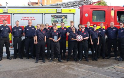 A group of Fire Cadets and trainers in front of a fire engine