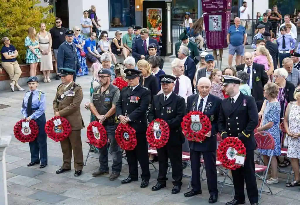 Station Manager Borham holding a RBFRS poppy wreath next to other organisations with their poppy wreathes