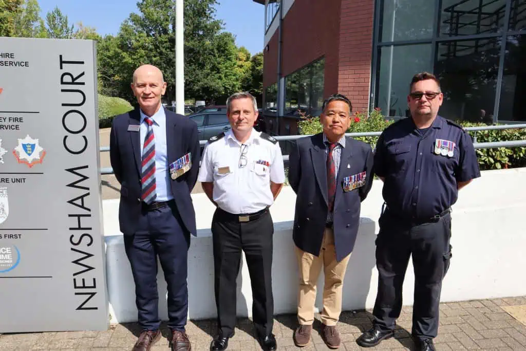 four members of staff stood outside HQ wearing their military medals