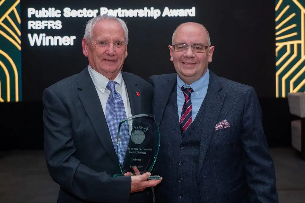 Sandy holding his award and standing next to Steve Lee.