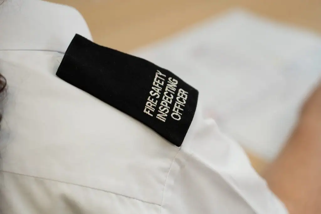 An epilate on a person's shoulder that reads Fire Safety Inspecting Officer