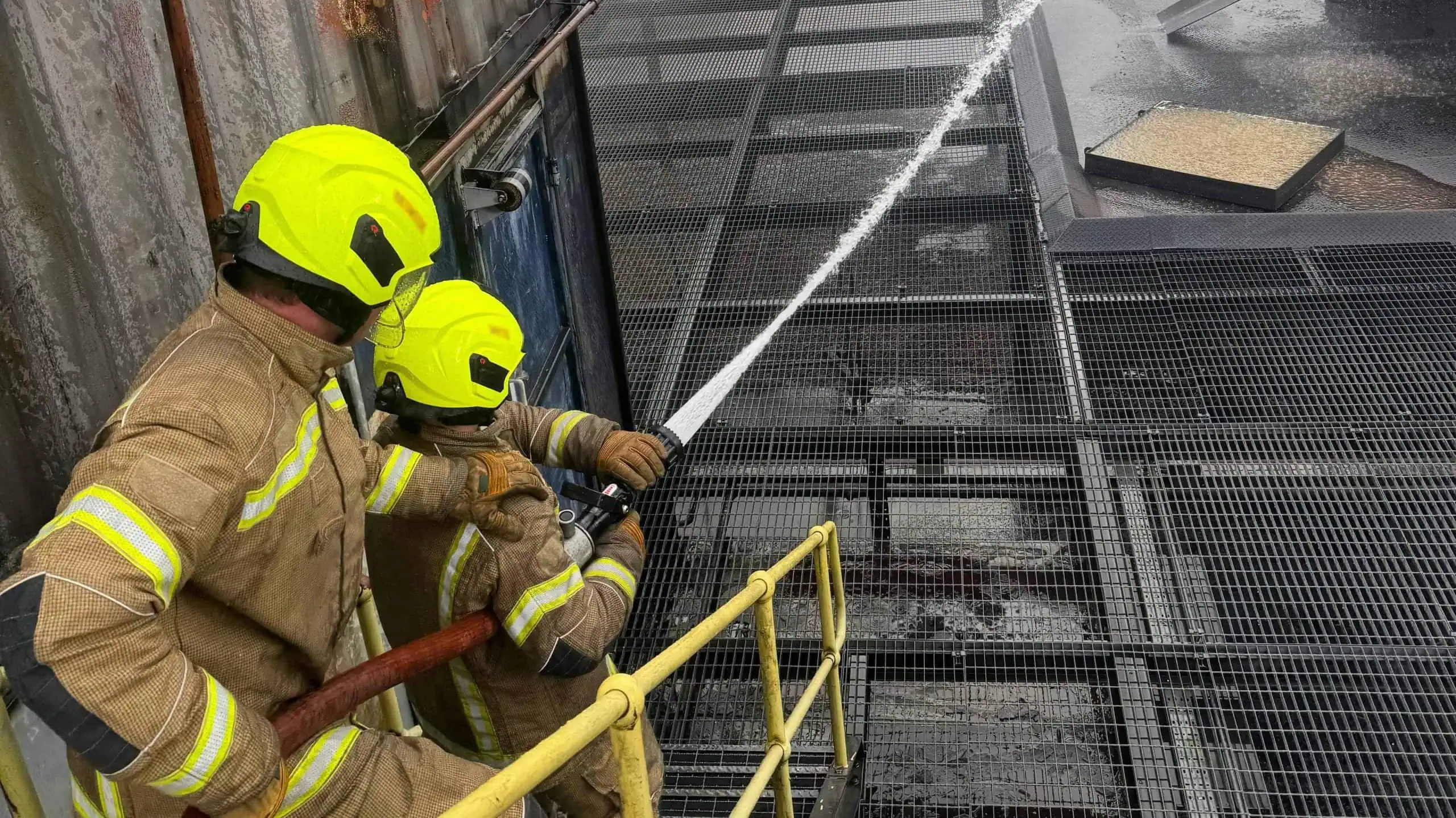 Two firefighters holding a hose
